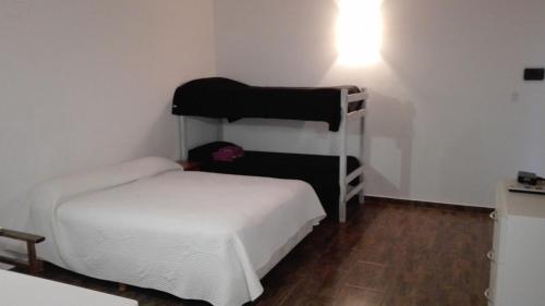 ein kleines Zimmer mit einem Bett und einem Etagenbett in der Unterkunft Verdeymar in Santa Clara del Mar