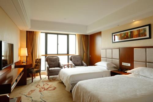Jiangningにあるラマダ 南京のベッド2台とテレビが備わるホテルルームです。