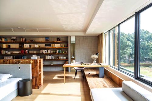 a living room with a desk and bookshelves at Anadu Private House in Huzhou