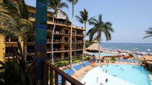a view of a resort with a swimming pool and the ocean at Cabañas del Capitan in Rincon de Guayabitos