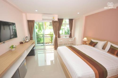 a hotel room with a large bed and a balcony at Sukkhamas Pirom in Nakhon Ratchasima
