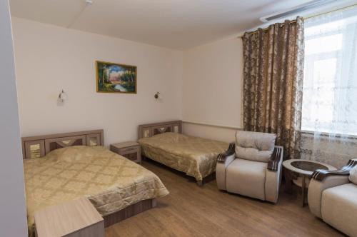 バイカリスクにあるMini Hotel Margobayのベッドルーム1室(ベッド2台、椅子、窓付)