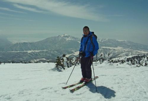 a man is standing on skis in the snow at Country Inn Mori no Gorilla in Kitashiobara