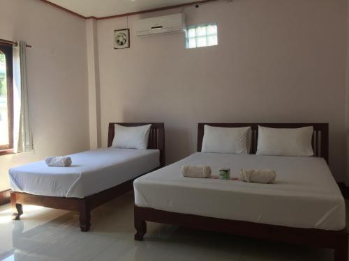 two beds sitting next to each other in a room at Mama Leurth Sunset Guesthouse in Don Det