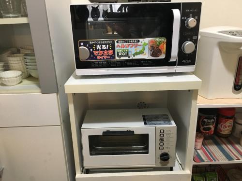 a microwave oven sitting on top of a white shelf at Shironoshita Guesthouse in Himeji