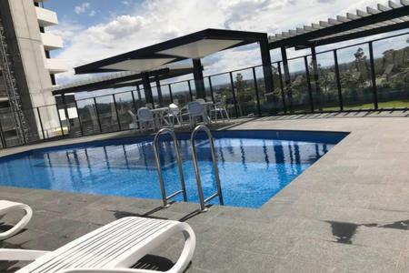 a swimming pool with a bench next to a building at Liverpool New Apt 2BR and 2Bath in Liverpool