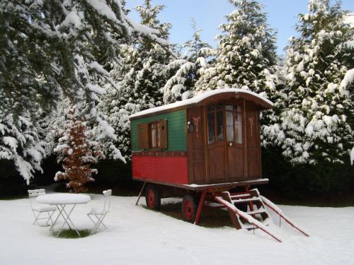 a train car sitting in the snow next to trees at Manoir de la Baronnie in Saint Malo