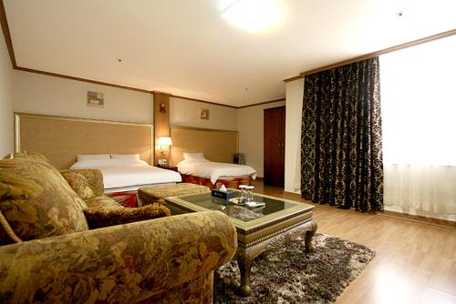 a hotel room with a couch and a bed at Changwon Olympic Hotel in Changwon