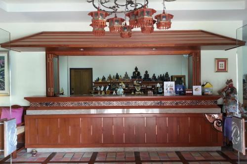 a wooden bar with a chandelier above it at Sripat Guesthouse SHA Extra Plus in Chiang Mai