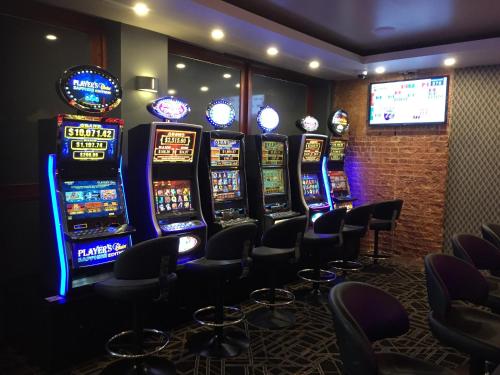 a row of slot machines in a room with chairs at Heritage Hotel Rockhampton in Rockhampton
