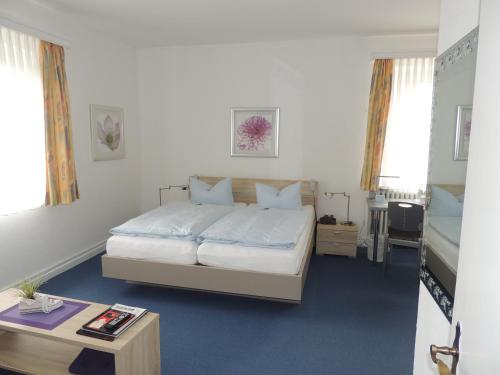 Schlafzimmer mit einem Bett und einem Couchtisch in der Unterkunft Hotel Stadt Munster in Munster im Heidekreis