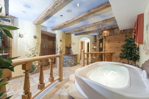 ein großes Bad mit Badewanne in der Mitte eines Zimmers in der Unterkunft Hotel Sonnhof in Großarl