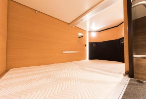 a bed in a room with a wooden wall at Ryoma Ikebukuro in Tokyo