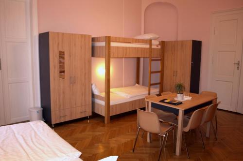 a room with two bunk beds and a table and a tableablish at Ciszterci Szállás Pécs in Pécs