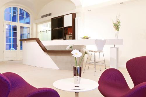 a kitchen with purple chairs and a vase with flowers on a table at Hapimag Ferienwohnungen Dresden in Dresden