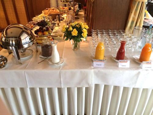a table with a white table cloth and some orange juice at Deutsches Haus Munster in Munster im Heidekreis