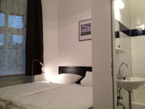 1 dormitorio con cama y lavamanos en Hotel-Pension Dorma, en Berlín
