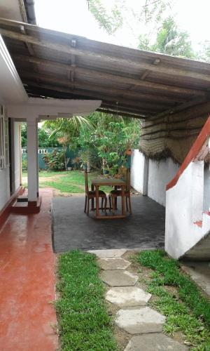 ミディガマ・イーストにあるOcean edge villaの屋根の下にテーブルと椅子付きのパティオ