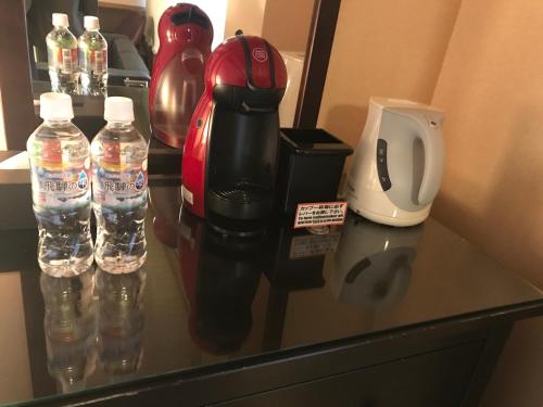 a red and black coffee maker on a counter with water bottles at Oyado Koto No Yume in Takayama