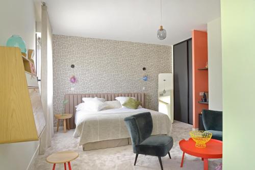 a bedroom with a bed and a table and chairs at En Marge in Aureville