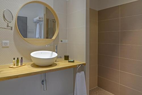 a bathroom with a sink and a mirror at En Marge in Aureville