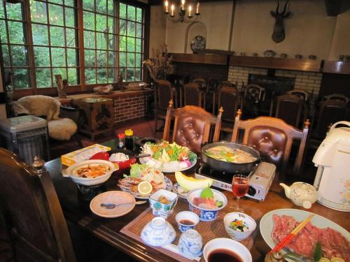 uma mesa com muitos pratos de comida em Onsen Inn 36So em Matsumoto