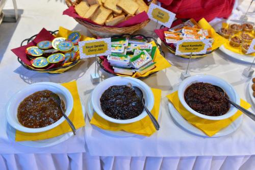 een tafel met kommen eten en desserts bij Te Stela Resort & SPA in Tirana