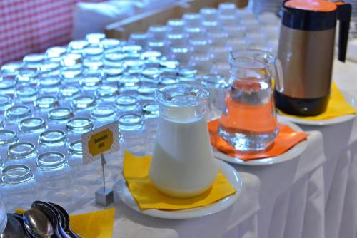 een tafel vol glazen melk en water bij Te Stela Resort & SPA in Tirana
