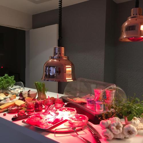 a table with plates of food on a counter with lights at ABC Hotel in Blankenberge