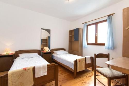 a bedroom with two beds and a table and a desk at House Fazana 975 in Fažana