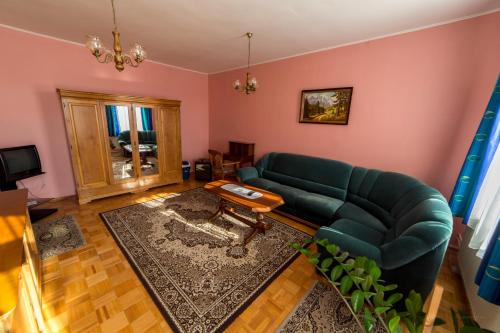 a living room with a green couch and a table at HOTEL Villa Romaine in Šahy
