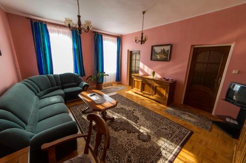 a living room with a couch and a television at HOTEL Villa Romaine in Šahy