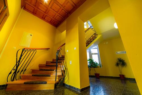 a hallway with yellow walls and stairs in a house at HOTEL Villa Romaine in Šahy