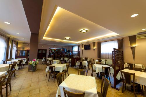 a dining room with tables and chairs and white tables at HOTEL Villa Romaine in Šahy
