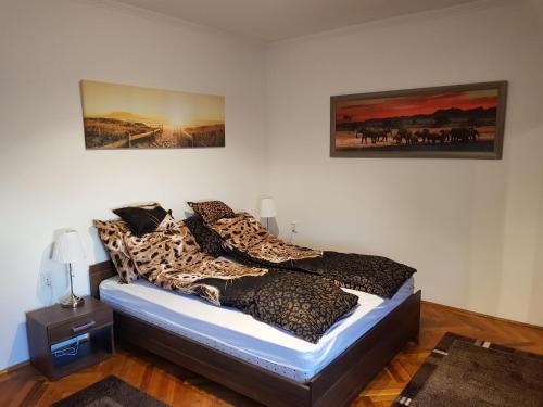 1 dormitorio con 1 cama con guepardos en Lia Apartman, en Kiskunhalas
