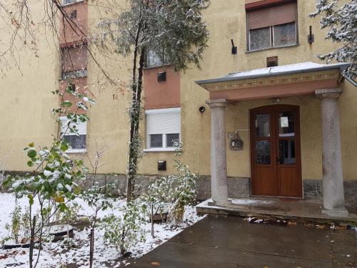 a front door of a building with snow on the ground at Lia Apartman in Kiskunhalas