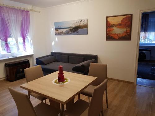 a living room with a table and a couch at Lia Apartman in Kiskunhalas
