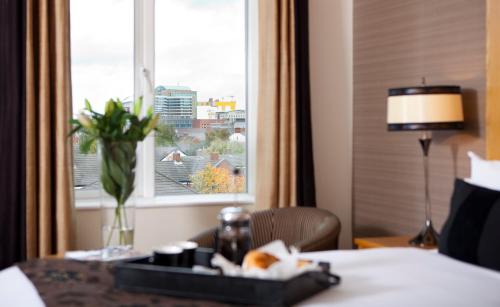 a hotel room with a table and a window at Tara Lodge in Belfast