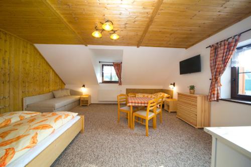 a bedroom with a bed and a table and a couch at Chata u Tří Sluk in Modrava