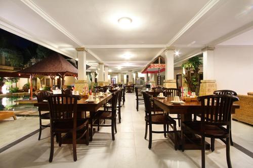 a dining room with tables and chairs in a restaurant at The Niche Bali in Legian