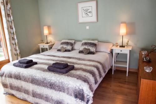サモエンヌにあるLa Terrasse - 3 bedrooms with private Hot Tubのベッドルーム1室(大型ベッド1台、ナイトスタンド2台付)