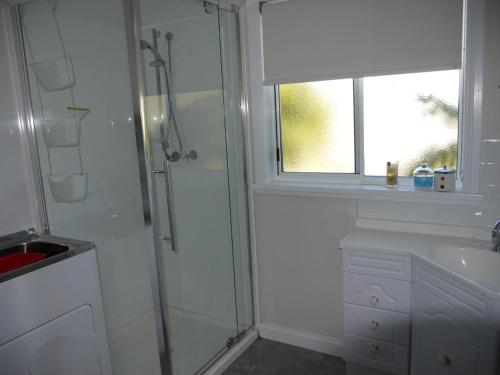 a bathroom with a shower and a sink and a window at Prime Location - Totally Refurbished in Bridport