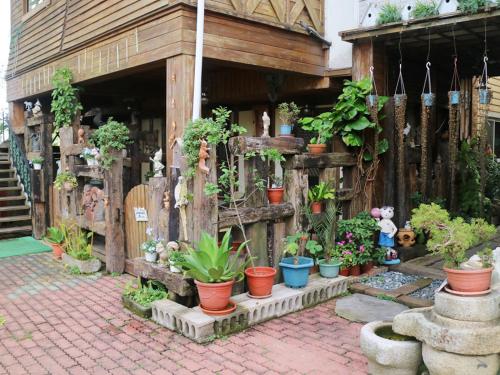a bunch of potted plants in front of a building at Taichung Xinshe Garden Life Homestay B&B in Xinshe