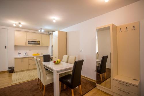 a dining room and kitchen with a white table and chairs at VIP Apartments in Sarajevo