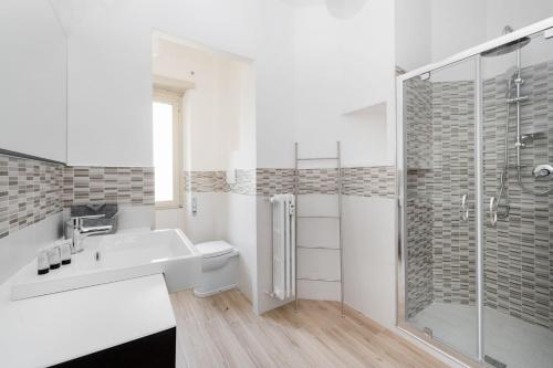 ein weißes Bad mit einem Waschbecken und einer Dusche in der Unterkunft Apartment Costanza in Rome in Rom