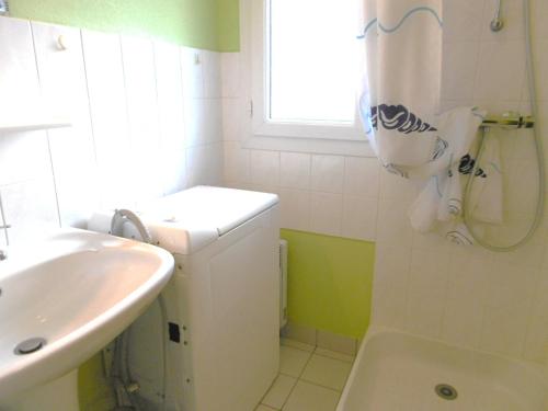 une salle de bain blanche avec lavabo et douche dans l'établissement Maisonnette Maria, à Saint-Gildas-de-Rhuys