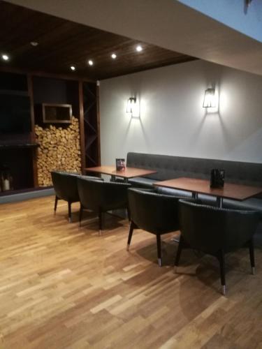 a dining room with tables and chairs and a wall at Richmond Park Hotel in Boʼness