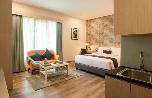 a hotel room with a bed and a sink at Treehouse Suites - Boutique Serviced Apartment in Jakarta