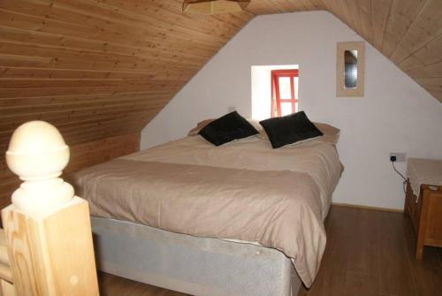 ein Schlafzimmer mit einem großen Bett im Dachgeschoss in der Unterkunft Aran Thatch Cottage in Inis Mor