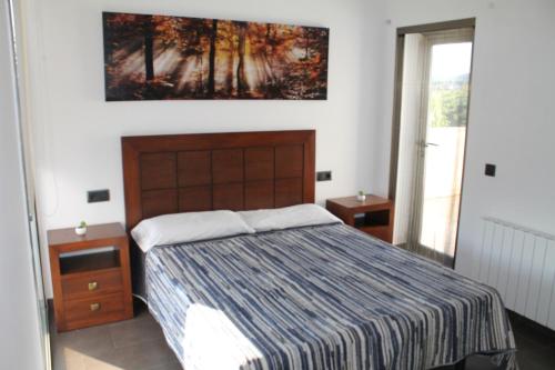 リョレート・デ・マルにあるVilla Asturiasのベッドルーム1室(ベッド1台付)が備わります。壁には絵画が飾られています。